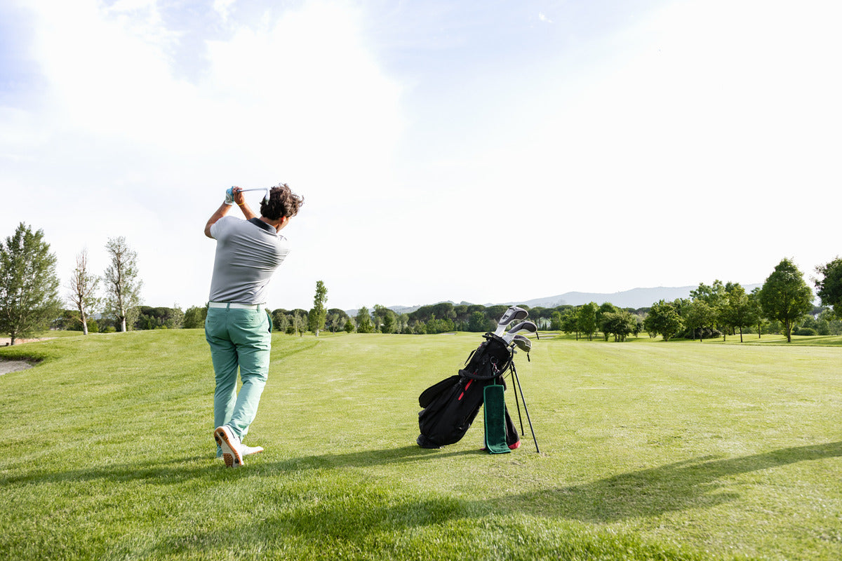 A golfer taking a swing on a fairway, aiming for a precise shot on a well-maintained golf course.
