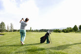A golfer taking a swing on a fairway, aiming for a precise shot on a well-maintained golf course.