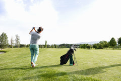 A golfer taking a swing on a fairway, aiming for a precise shot on a well-maintained golf course.