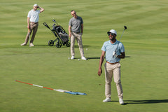 A group of golfers engaging in a fun and professional golf experience on a putting green.