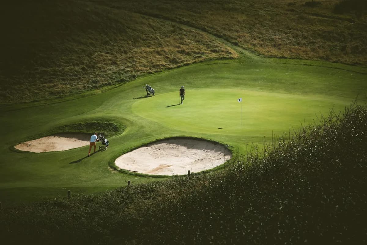 A well-maintained parkland golf course near Manchester with mature trees lining the fairway