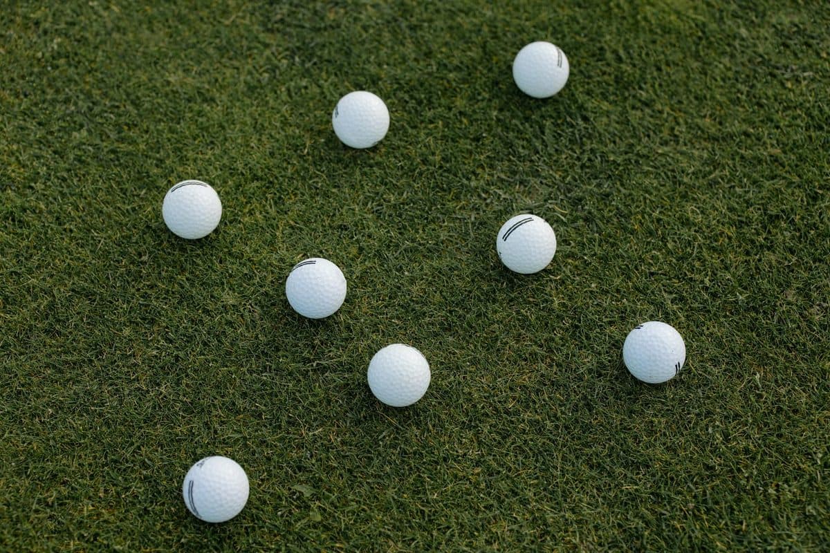 A golfer mid-iron swing on a practice fairway working on ball contact
