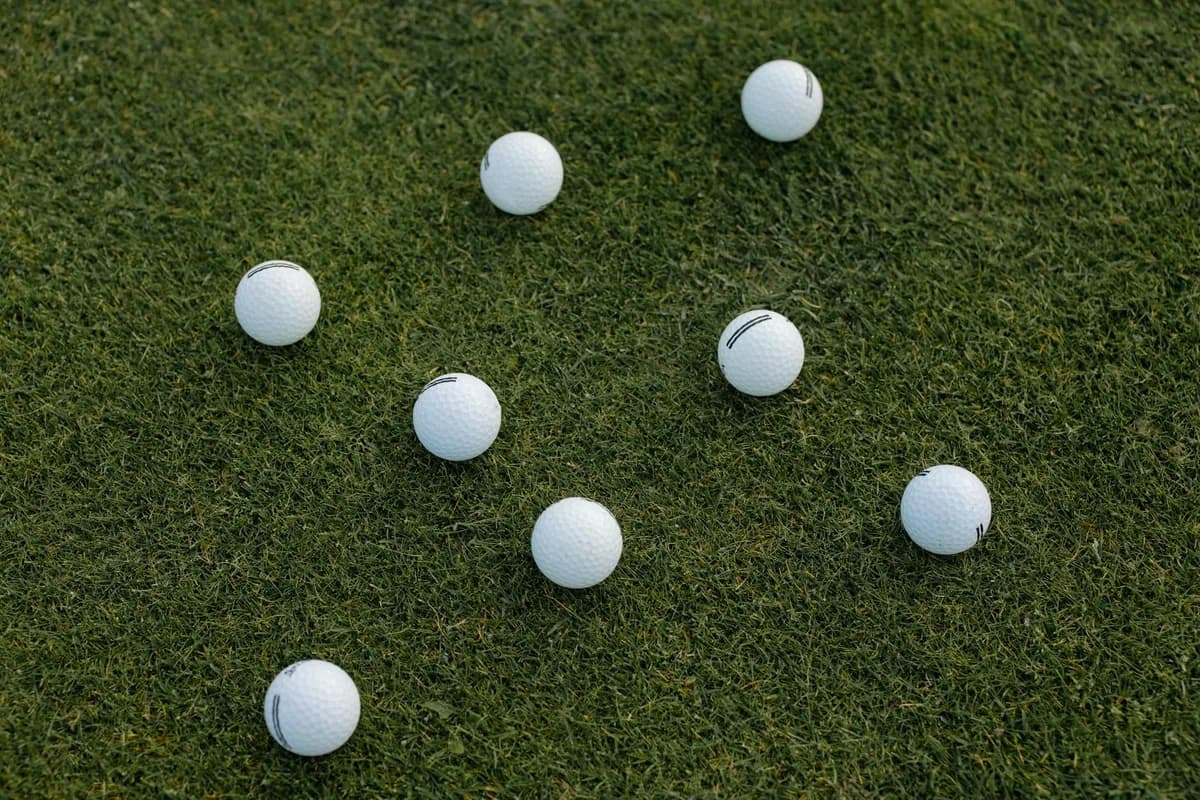 A golfer mid-iron swing on a practice fairway working on ball contact