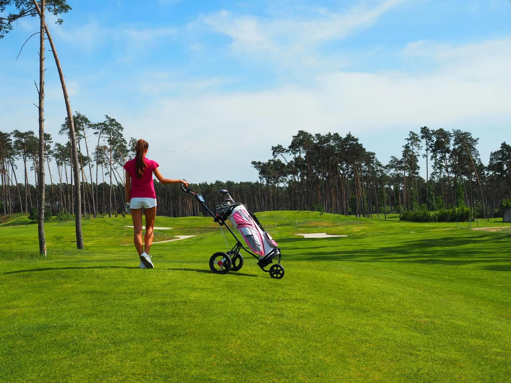 Rolling downland golf course with open fairways under a clear sky