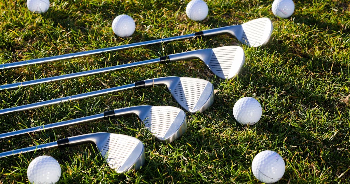 A selection of colourful golf balls and tees arranged on green grass