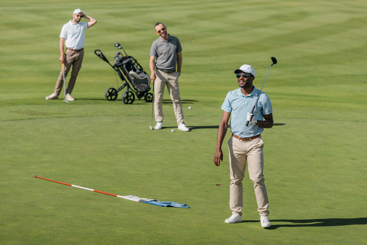 A group of golfers engaging in a fun and professional golf experience on a putting green.