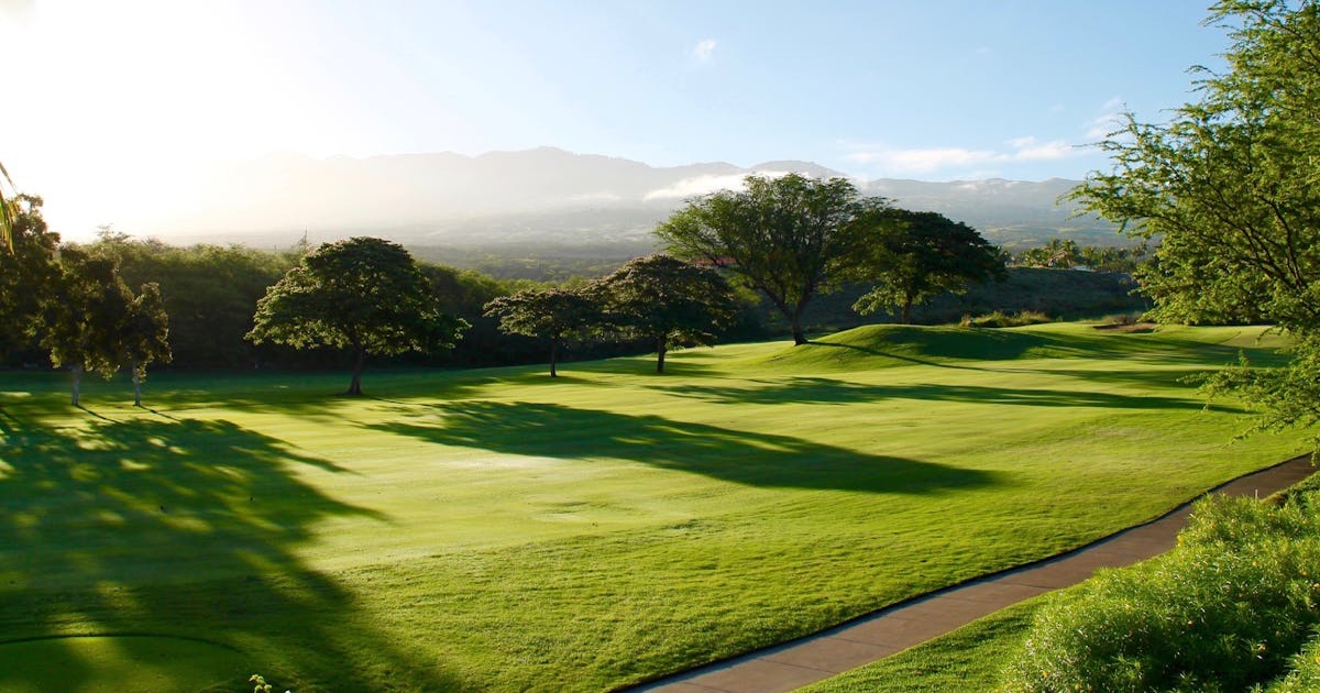 A sweeping view of a championship golf course with rolling hills and bunkers