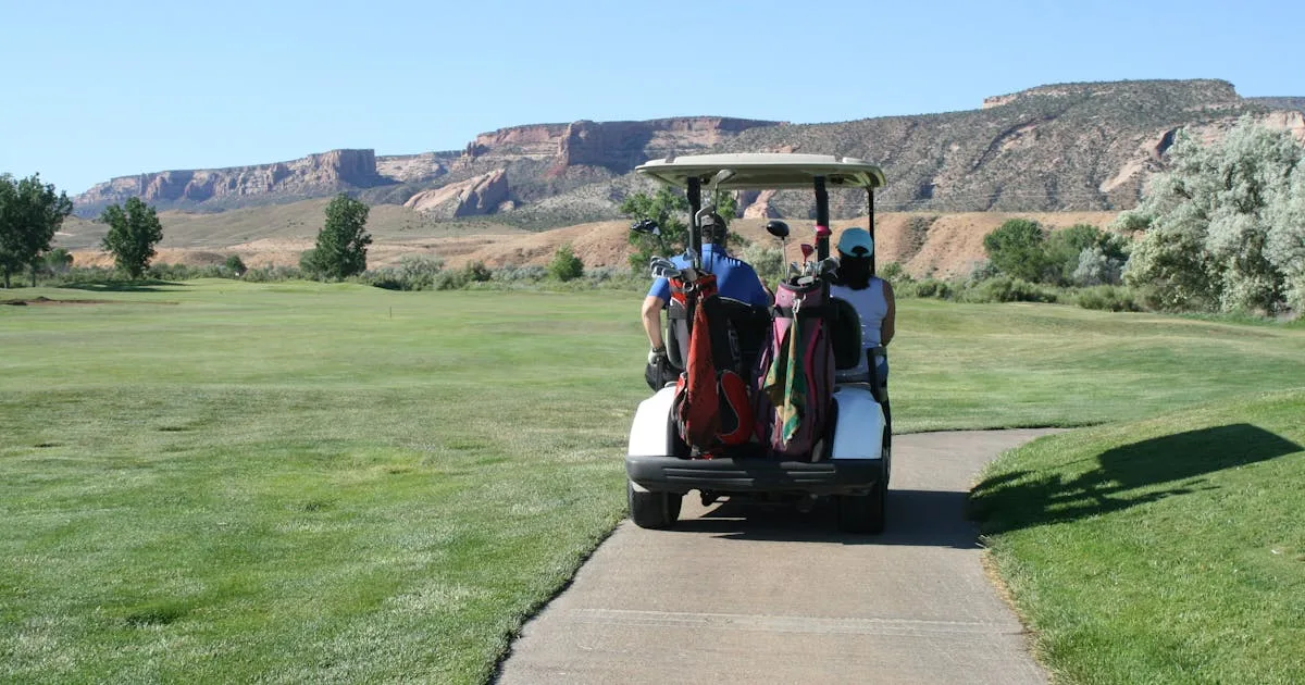 A golfer mid-swing on a lush green fairway on a clear day