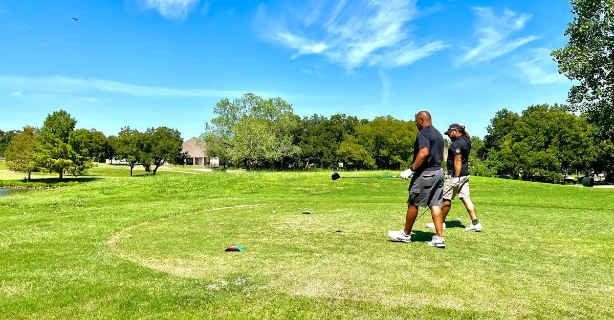 Two golfers walking a sunny fairway together carrying their bags