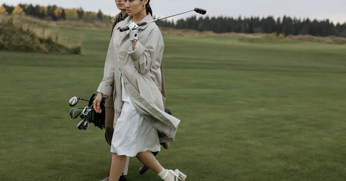 A couple walking together with golf equipment on a lush green course