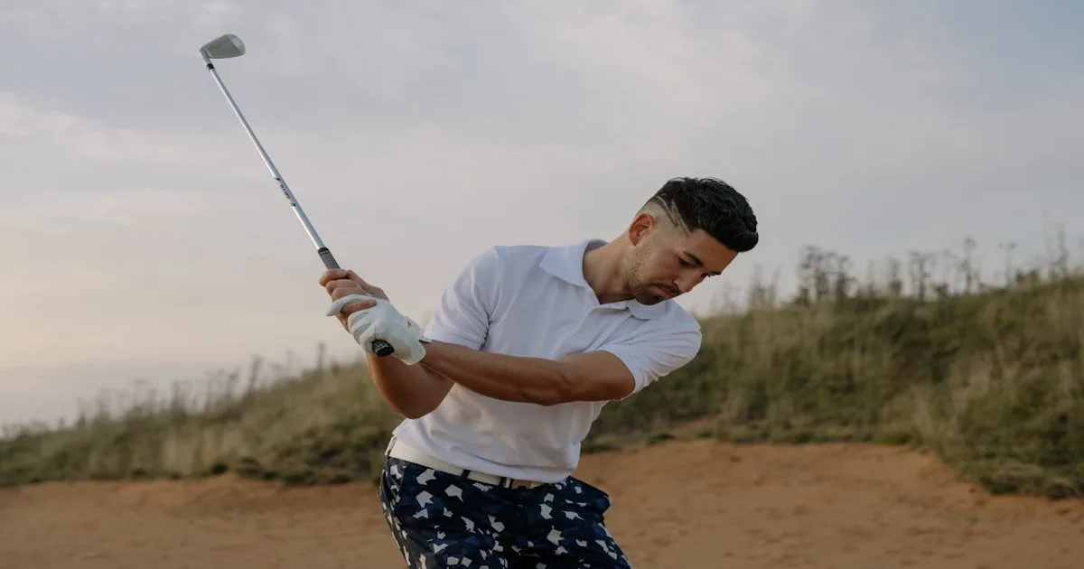 A golfer teeing off on a scenic golf course at golden hour