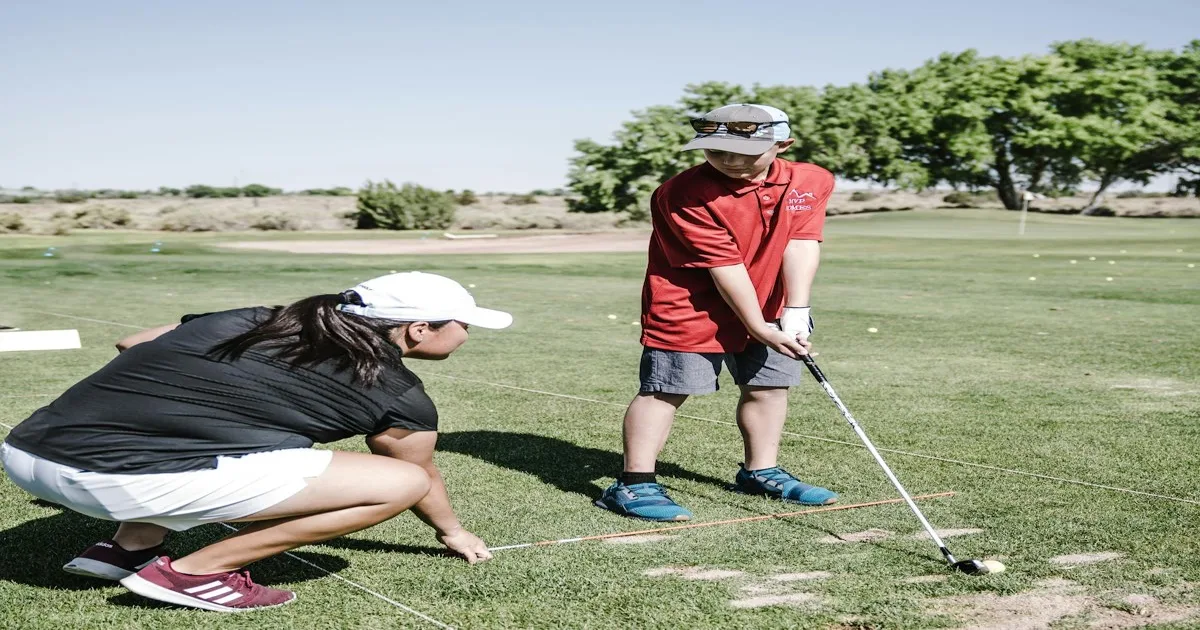 A golf club resting next to a ball on a well-kept fairway