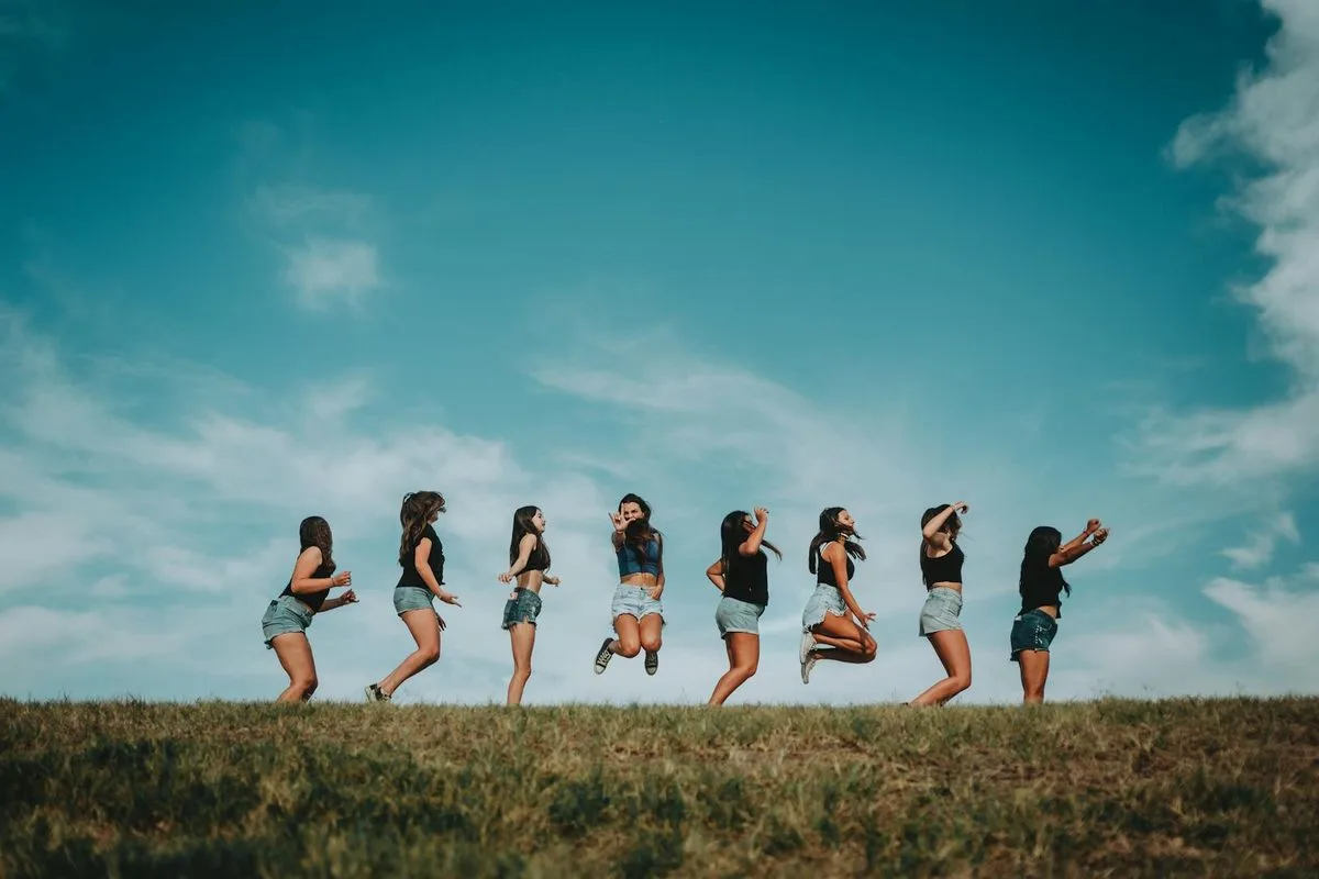 A group of women laughing on a golf course on a sunny summer day