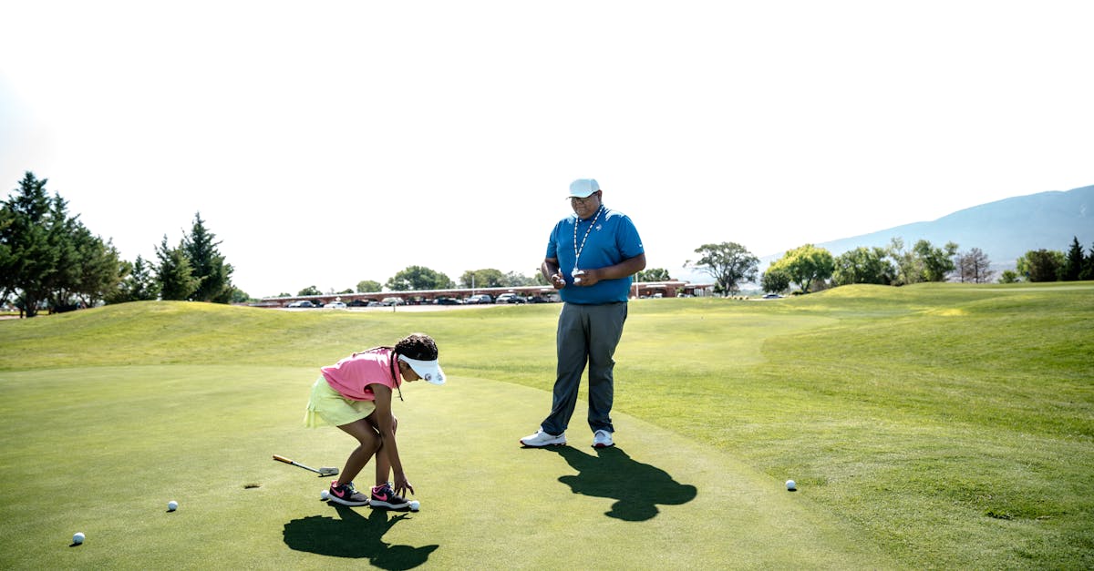 A golfer receiving on-course instruction from a PGA professional on a sunny golf course