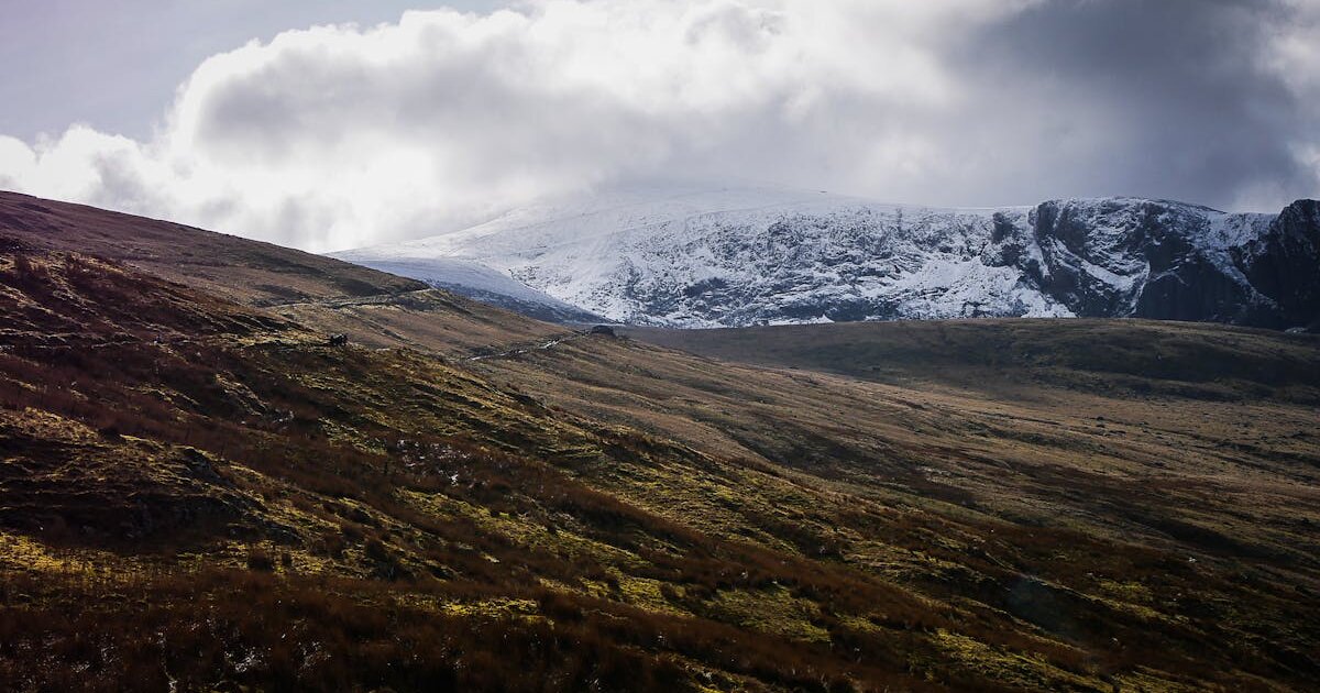 Snowdonia mountain range with green valleys and dramatic skies in North Wales