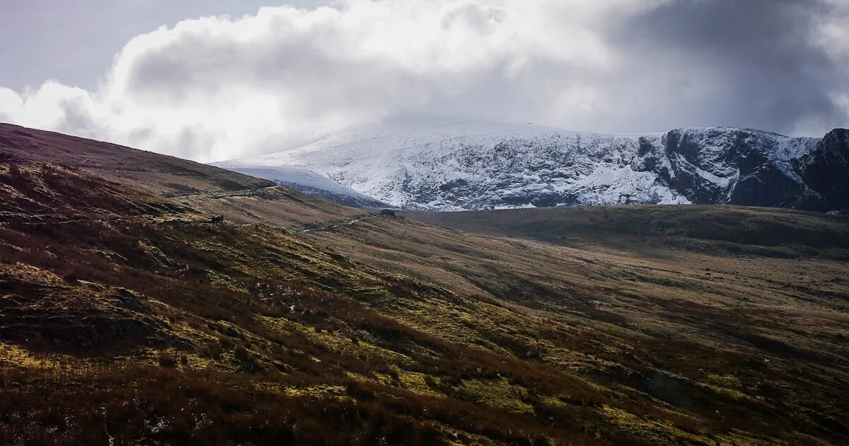 Snowdonia mountain range with green valleys and dramatic skies in North Wales