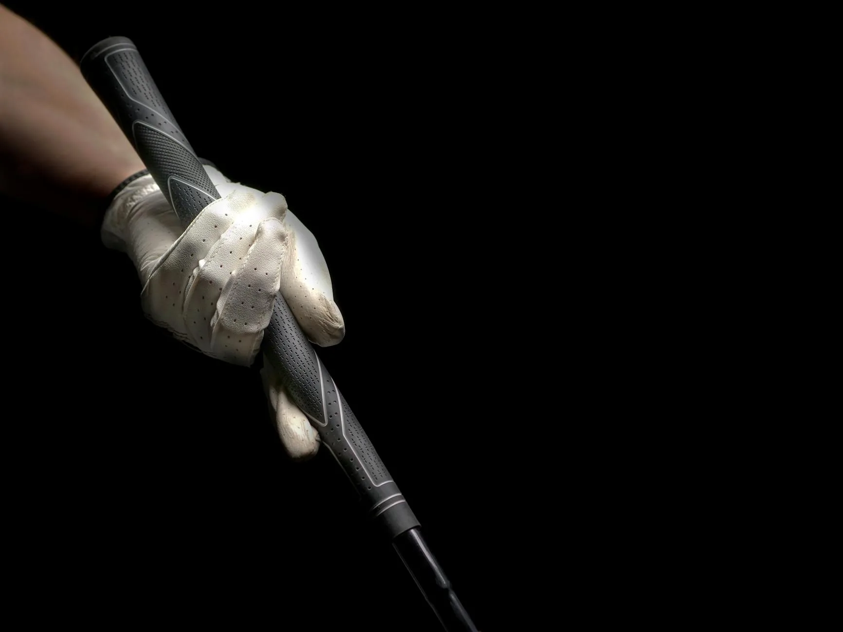 Close-up of a golfer's hands gripping a club at address