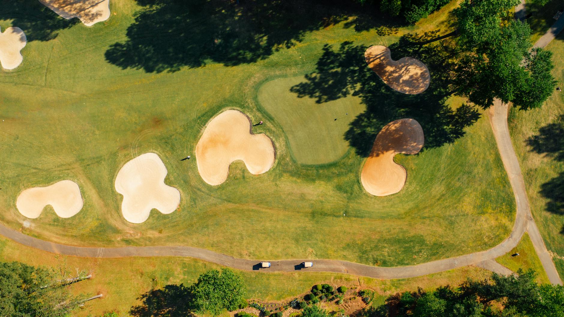 An aerial view of a golf course showing fairways, greens, and hazards
