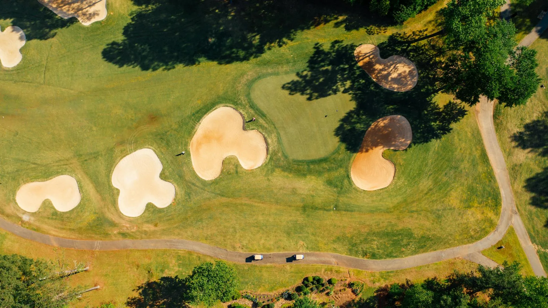 An aerial view of a golf course showing fairways, greens, and hazards
